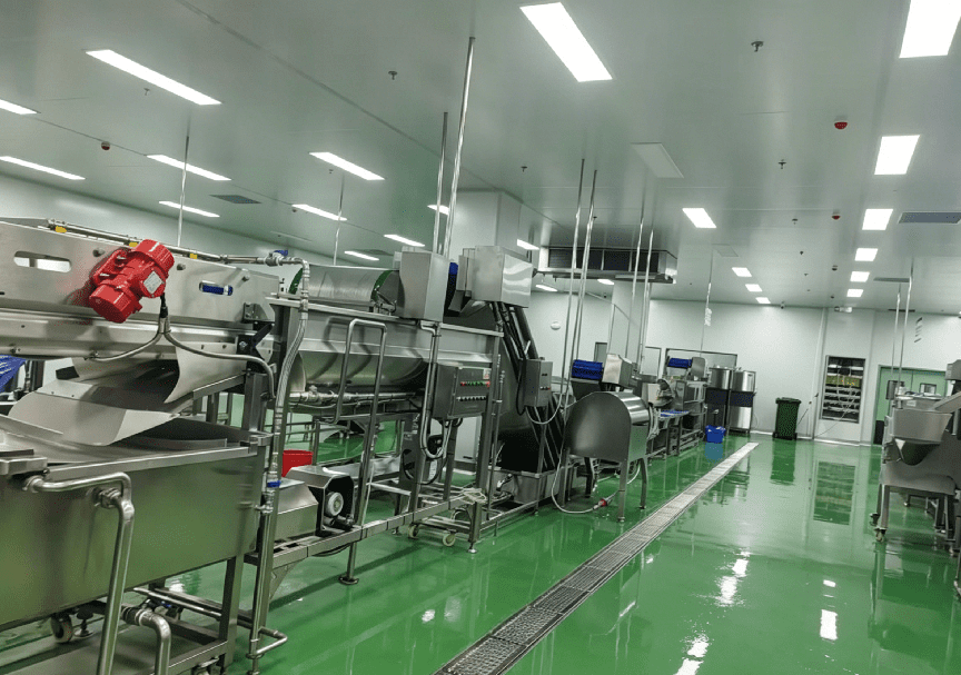 Hygienic food processing room with green epoxy floor and stainless steel production line equipment under controlled cooling